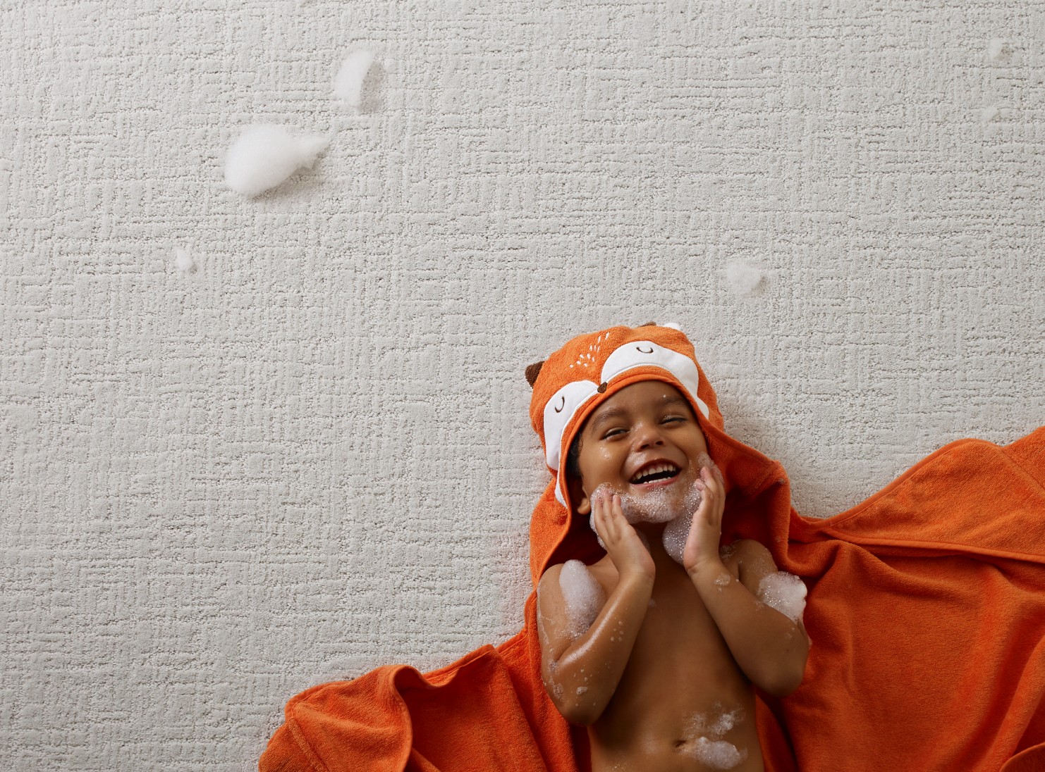 Kid enjoying laying on Carpet | Kirkland's Flooring