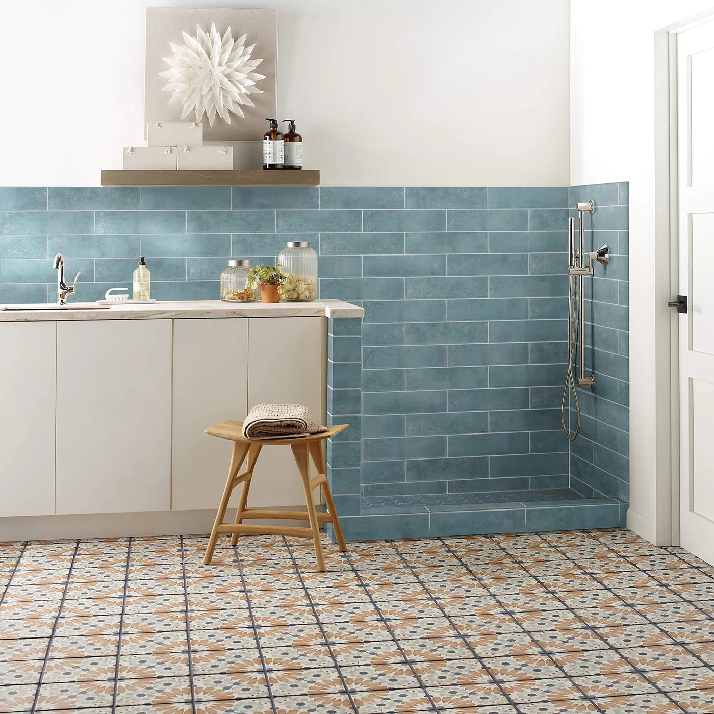 Mint blue subway tile on the wall and multi-colored patterned tile on the floor | Kirkland's Flooring